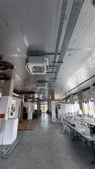 Air conditioning cassette installed in a long open-plan room