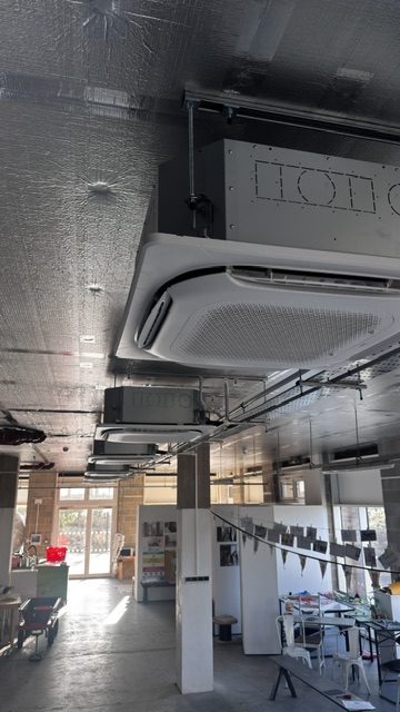Four-way ceiling cassette air conditioner in an open-plan teaching space
