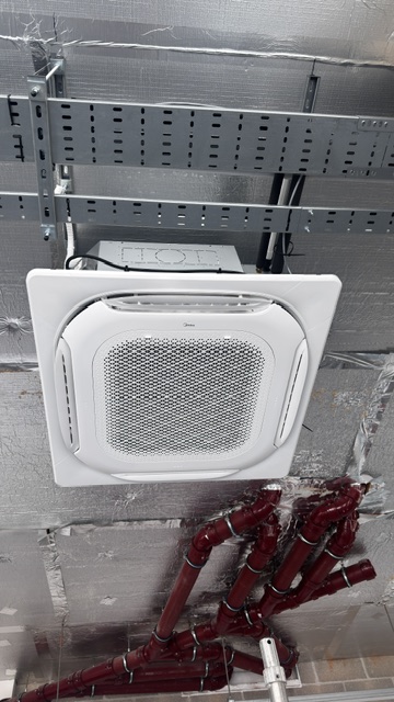 Ceiling cassette air conditioner installed among exposed ceiling services