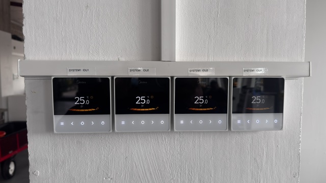 Four zone air conditioning wall controllers mounted on a column
