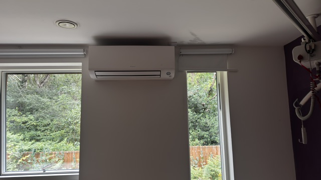 Wall-mounted air conditioning unit installed above a classroom window